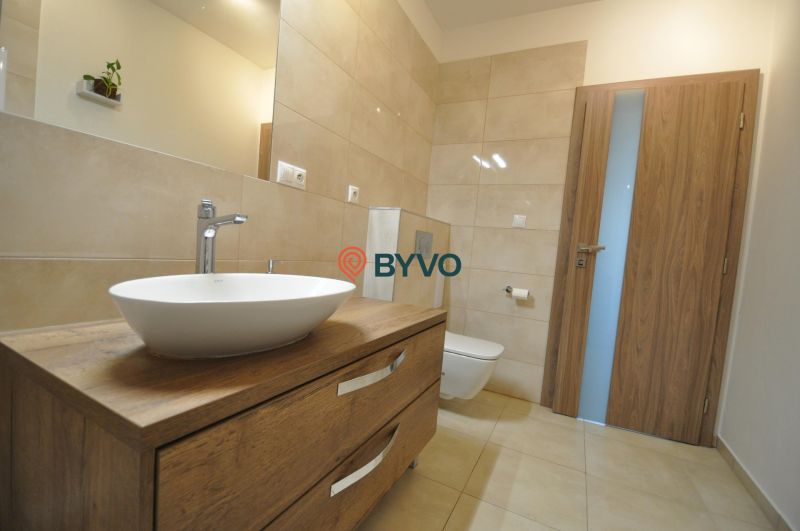 Bathroom in a 3-room apartment with a sink, wooden decor flooring, and a toilet.
