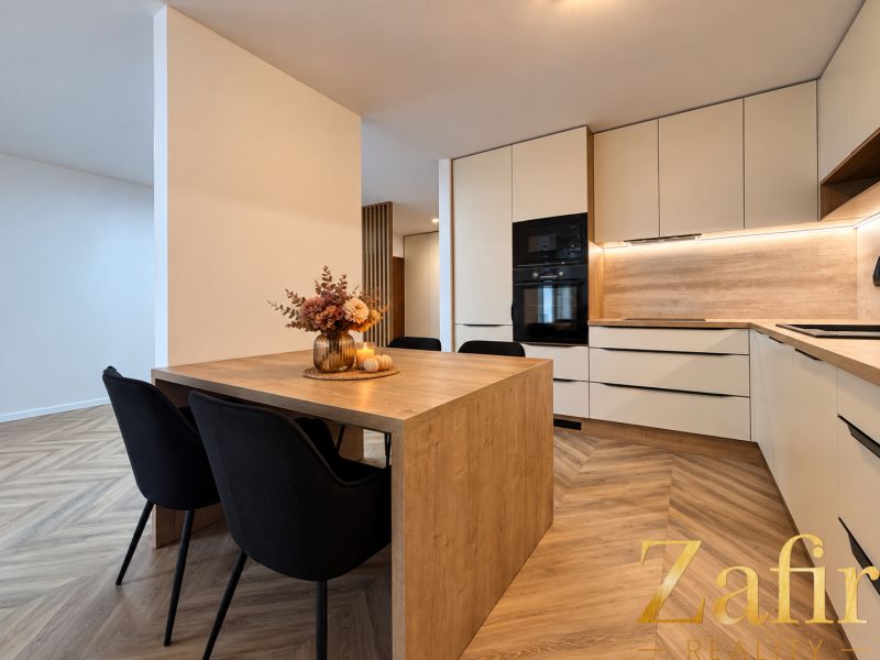 A kitchen in a 3-room apartment with a wooden decor floor and a decorative table.
