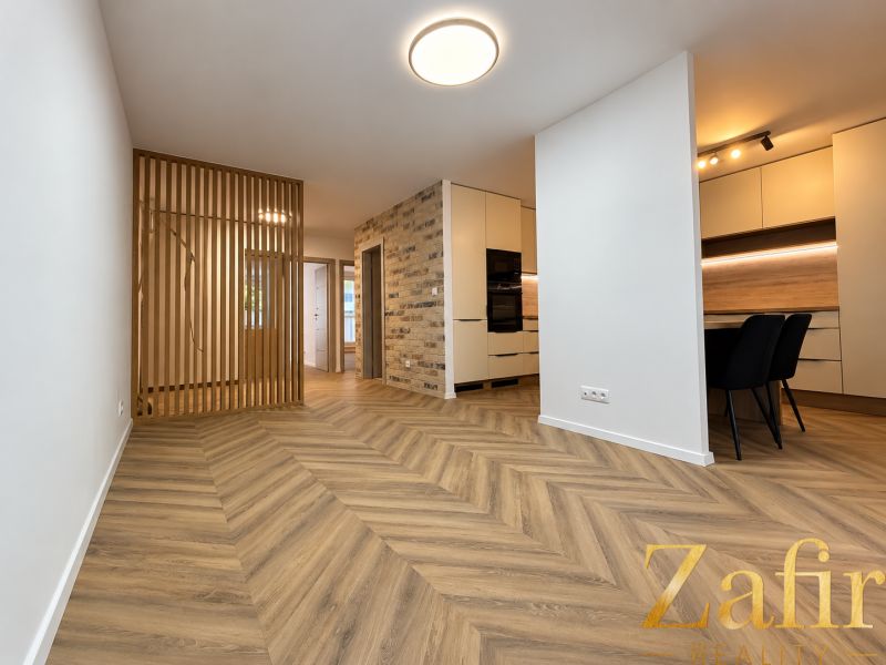 A kitchen with a dining area and a wooden decor floor in a 3-room apartment.