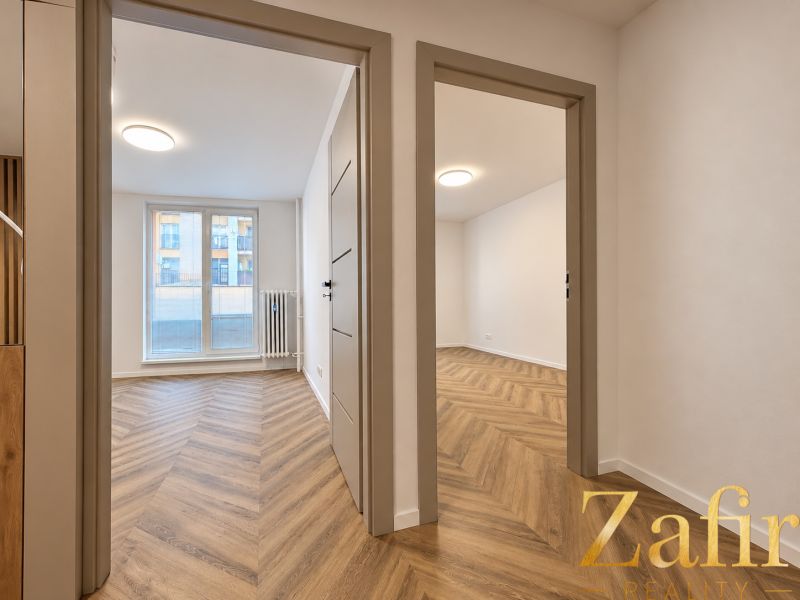 Interior of a 3-room apartment with a wooden decor floor and plenty of natural light.