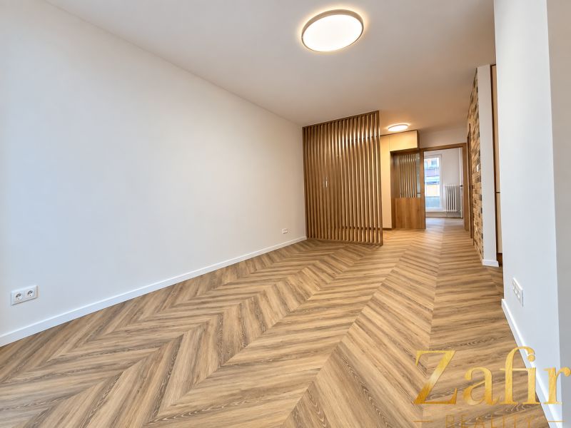 Interior of a 3-room apartment with a wooden decor floor and wooden partitions.
