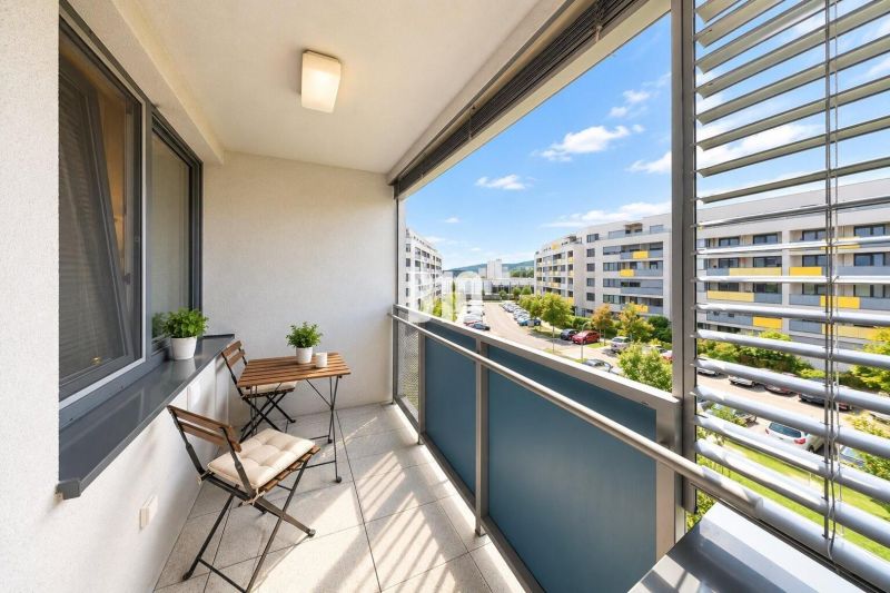 The balcony of a 2-room apartment on Malokrasňanská Street in Bratislava III with outdoor seating.
