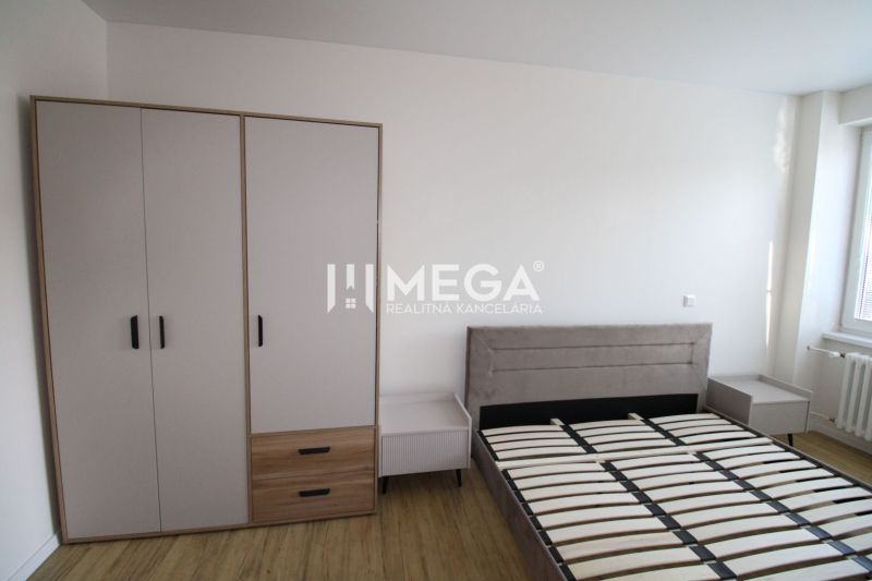 Bedroom in a 2-room apartment with a bed, nightstands, and a wardrobe on a floor with a wooden decor.