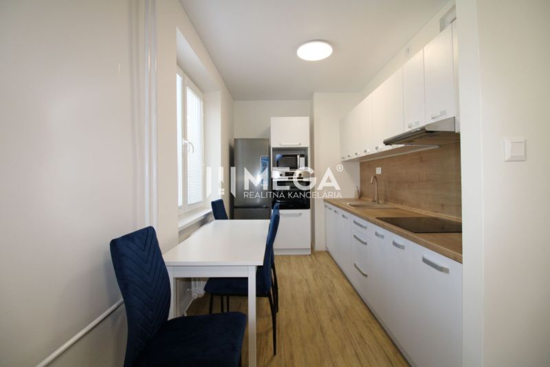 A kitchen with a table and a wooden decor floor in a 2-room apartment.