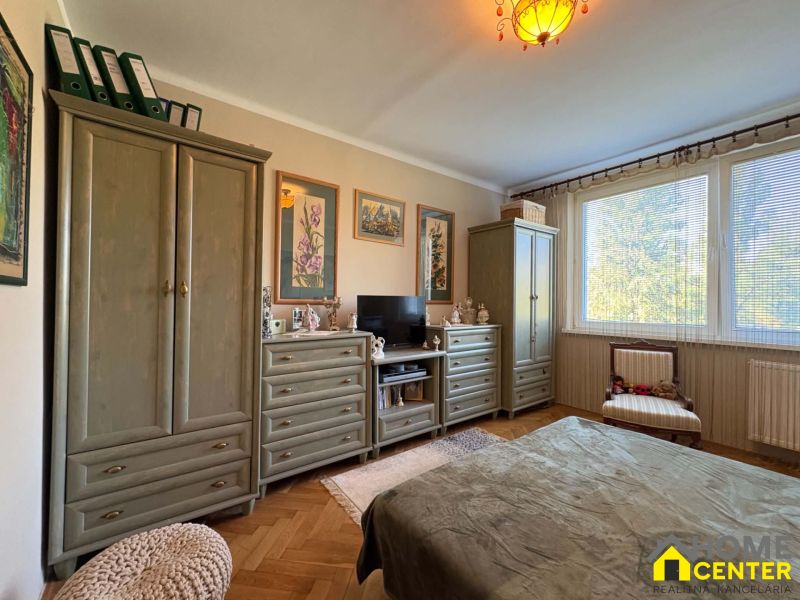 A bedroom with pistons, decorative cabinets, and a wooden decor floor in a 3-room apartment.