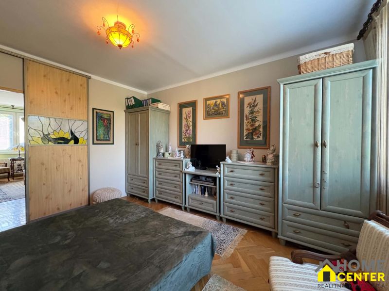 A bedroom in a 3-room apartment with decorative lighting, a wardrobe, and a dresser.