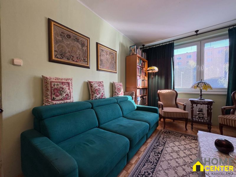 Living room in a 3-room apartment with a turquoise sofa and decorative pillows.