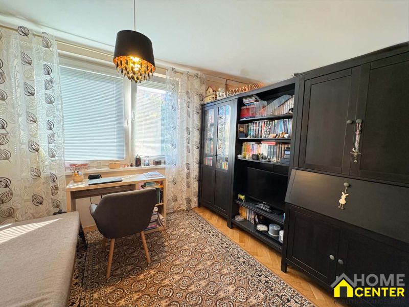 A workspace with a desk, chair, and cabinets, 3-room apartment, floor with wood decor.