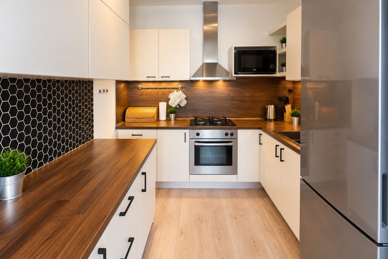 A kitchen in a 2-room apartment with wooden decor and black hexagonal tiles.