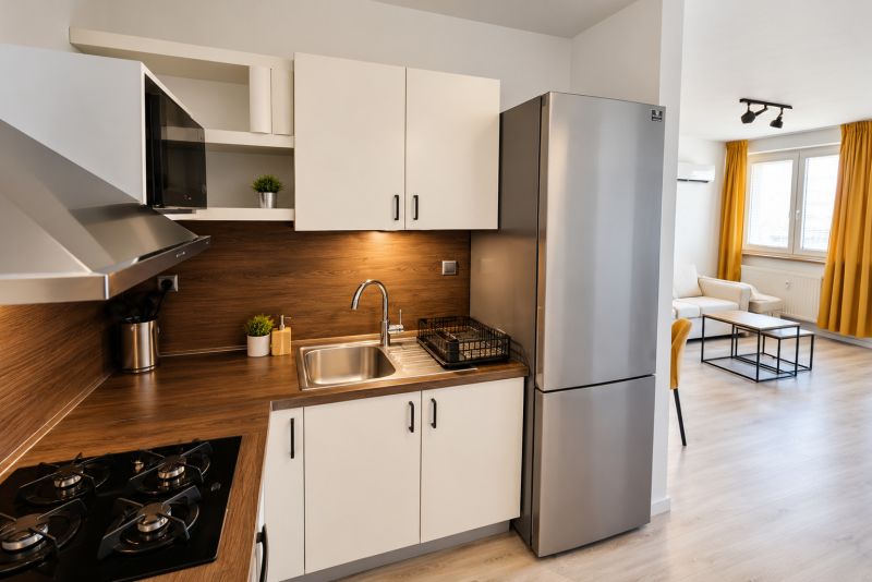 A kitchen with a wooden decor floor and stainless steel appliances in a 2-room apartment.