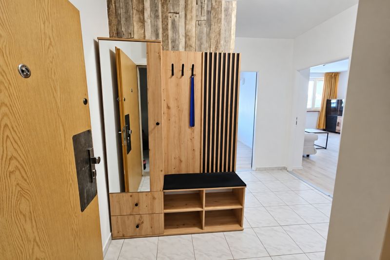Entrance hallway with wooden furniture and tiles in a 2-room apartment.