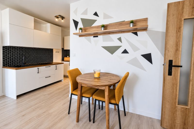 A kitchen corner in a 2-room apartment with a wooden decor floor and a geometric wall design.