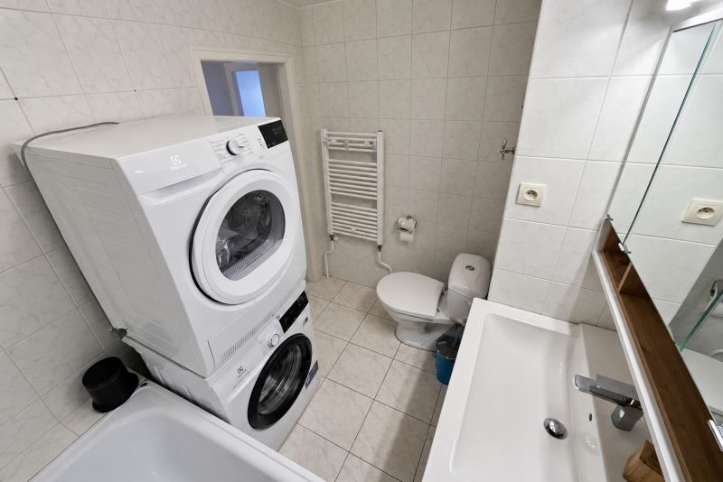 Bathroom with appliances and sanitary ware in a 2-room apartment, ceramic tiles and flooring.