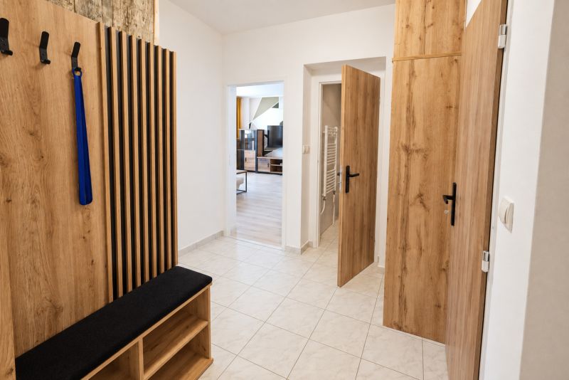 Hallway with a coat rack and entrance to the living room in a 2-room apartment, wooden decor.