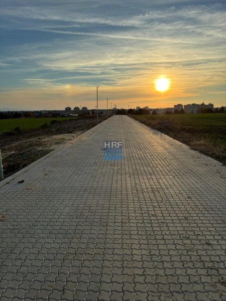 A paved road in Vinohrady in Senica at dusk with a view of the city.