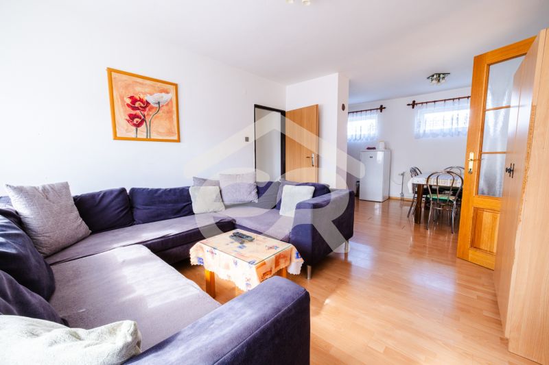 Living room with a dark sofa and a wooden decor floor in a family house.