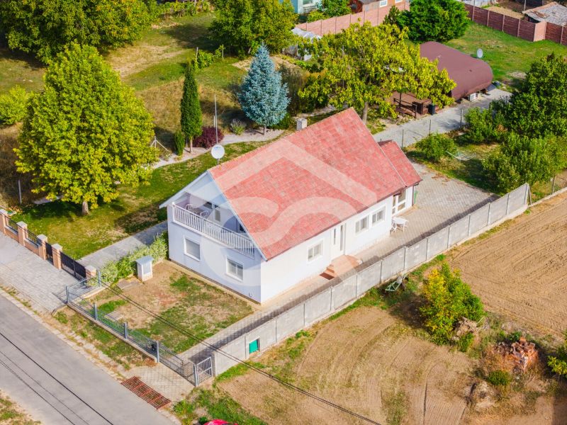 A family house on Nová Street in Podhájska surrounded by greenery and fields, with a terrace.