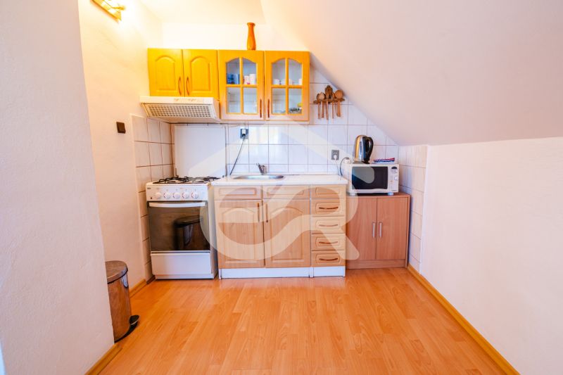 A kitchen in a family house with a wooden decor floor and a stove.