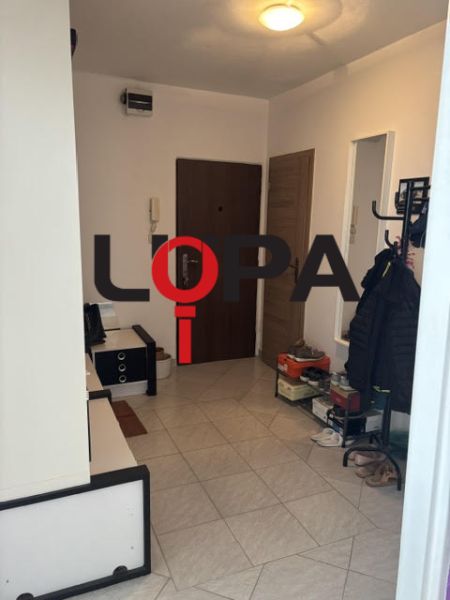 Entrance hall in a 2-room apartment with tiles and light furniture.