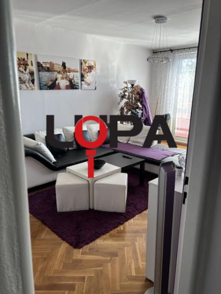 A comfortable living room with a wooden decor floor in a sought-after 2-room apartment.