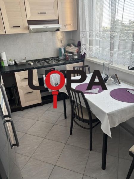 Kitchen in a 2-room apartment with a dining table and a kitchen unit.