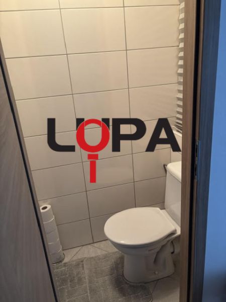 A toilet with simple tiles and flooring in a 2-room apartment.