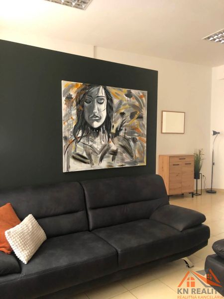 Living room with a gray sofa, a striking painting, and light tiles in a 2-room apartment.
