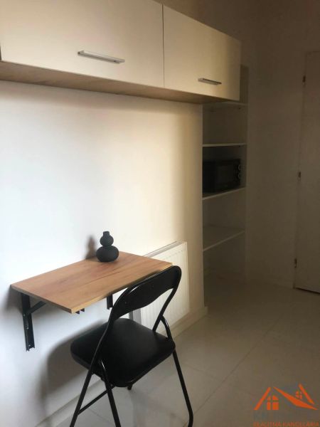 A work corner in a 2-room apartment with a folding table and a shelf.