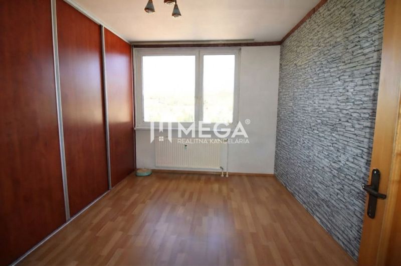 A room with a wooden decor floor and a built-in wardrobe in a 3-room apartment.