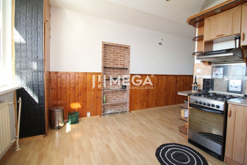A kitchen in a 3-room apartment with a wooden decor floor and brick cladding.