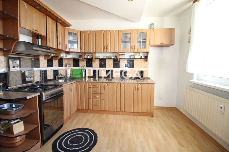 A kitchen in a 3-room apartment with a wooden decor floor and a functional kitchen unit.