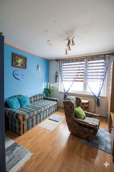 Colorful living room with a sofa and an armchair, 3-room apartment, floor with wood decor.