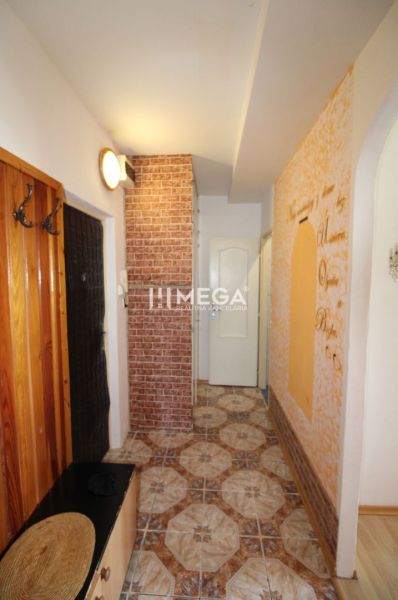 A hallway in a 3-room apartment with a decorative wall and patterned tiles.