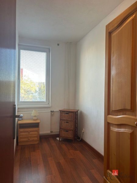 A small room in a 2-room apartment with a floor featuring a wooden decor.