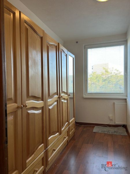 A hallway with a built-in wardrobe in a 2-room apartment and a floor with a wooden decor.