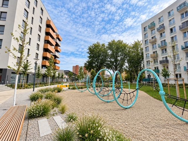 Children are playing in the playground between apartment buildings at Muchovo Square in Bratislava.
