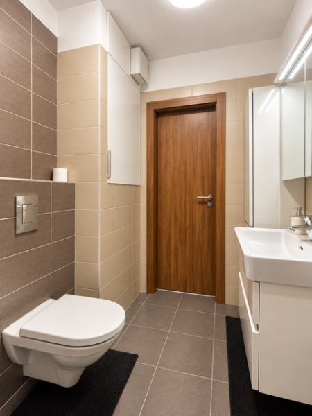Bathroom in a 2-room apartment with tiles and a wall-mounted toilet.