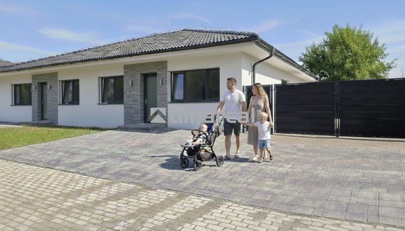 A family house in Hôrka nad Váhom with a family on a paved driveway.