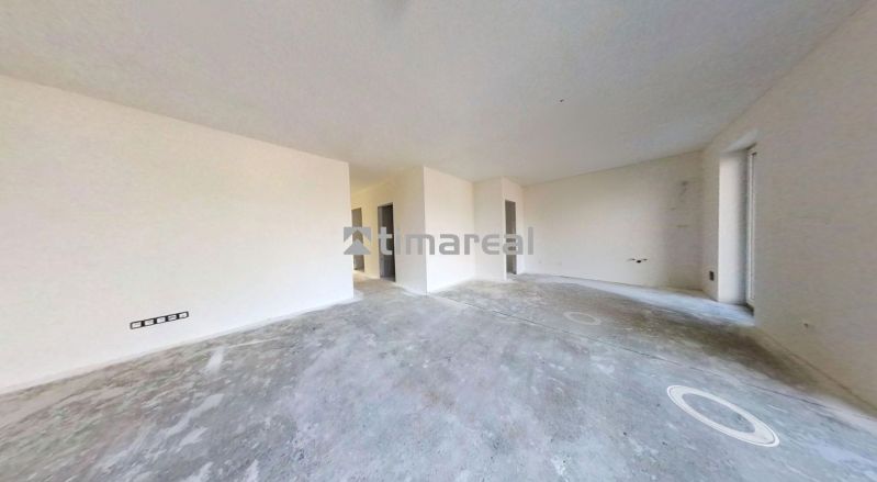 Empty room in a family house with a concrete floor and white walls.