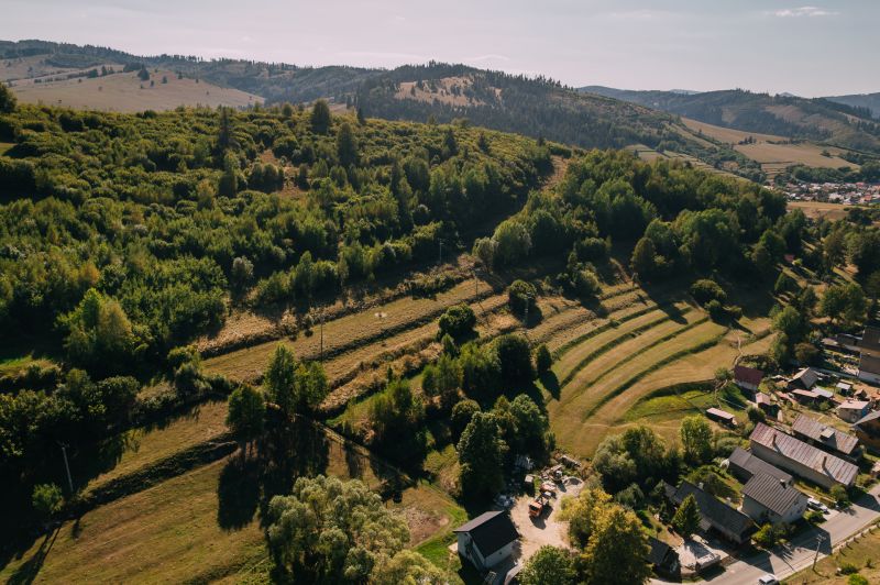 Aerial view of green hills and houses on Školská Street in Čierny Balog.