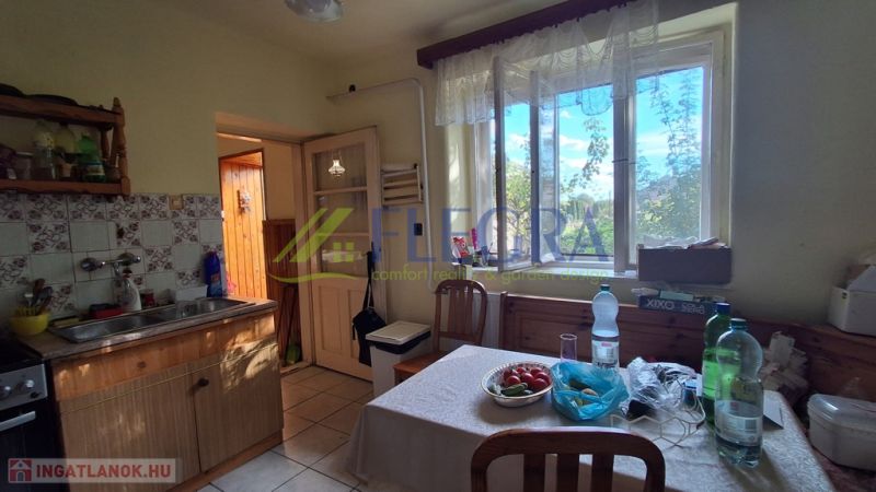A kitchen in a family house with a window, wooden furniture, and equipment on the table.