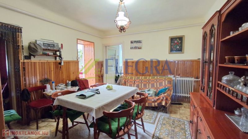 Living room in a family house with a dining table and a display cabinet.