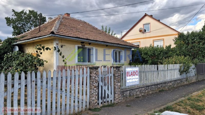 A family house in Tornyosnémeti with a brick roof and a colorful fence.