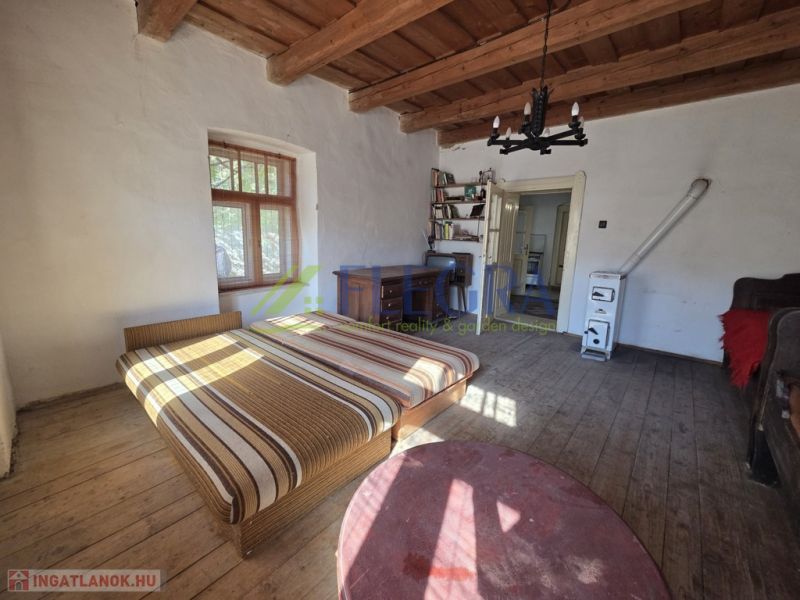 A bedroom in a family house with a bed and a wooden decor floor.
