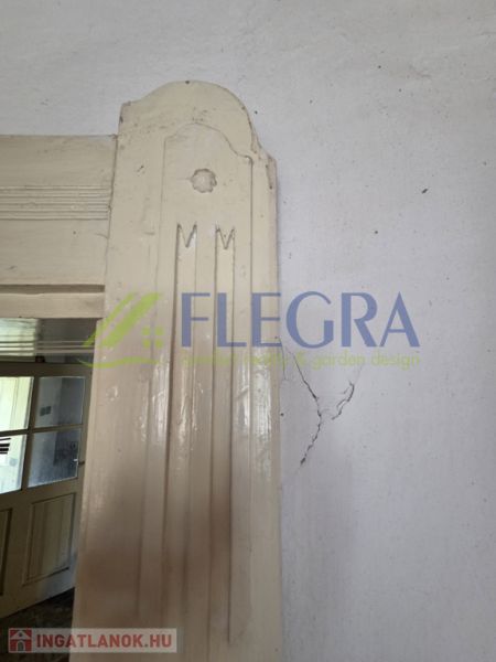 The interior of a family house with a crack in the wall near the door.
