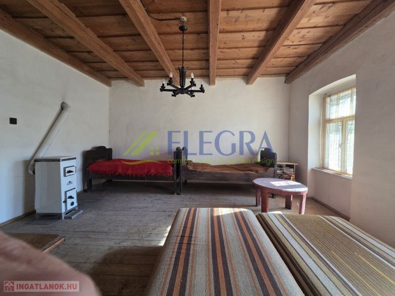 A room in a family house with a wooden ceiling and a tiled stove.