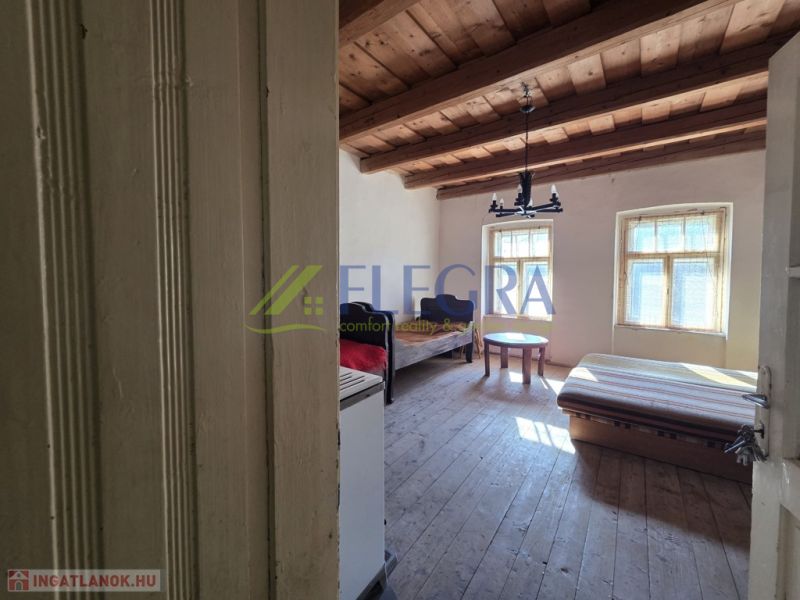 A room in a family house with a wooden ceiling and simple furniture.