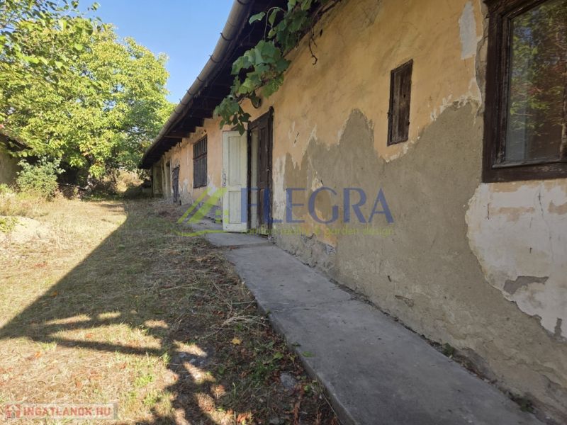 A family house in Hejce in need of renovation, with old plaster and a landscaped garden.