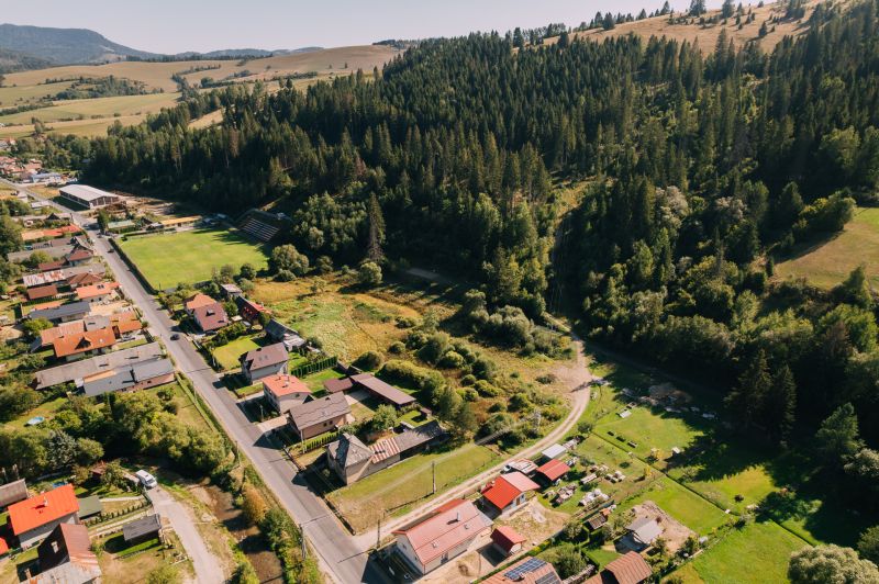 Aerial view of residential plots in Čierny Balog on Švermova Street surrounded by forests.