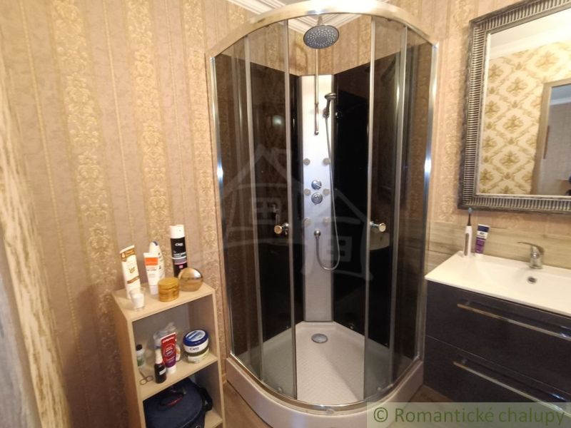 Bathroom in a family house with a round shower cabin and a mirror.